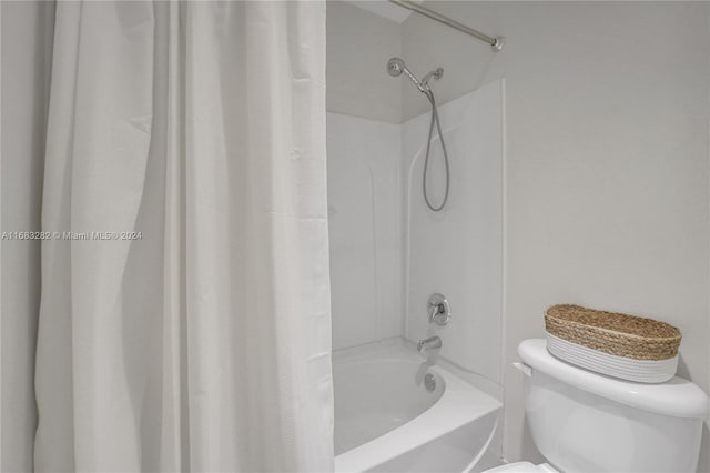 bathroom with toilet and shower / tub combo with curtain