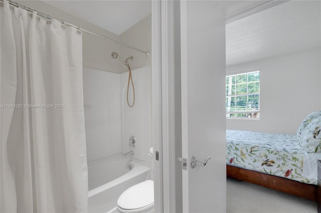 bathroom with shower / tub combo with curtain and toilet