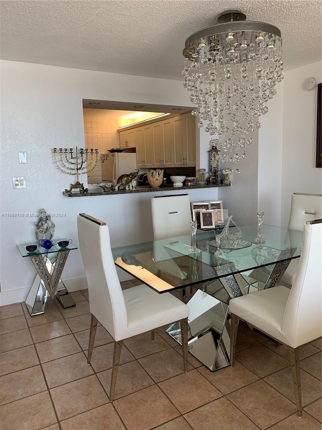 dining room featuring a notable chandelier, a textured ceiling, and light tile patterned floors