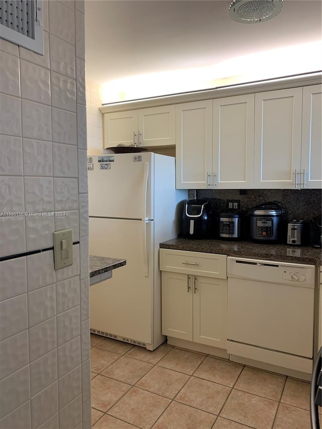 kitchen featuring white appliances, decorative backsplash, light tile patterned flooring, and white cabinets