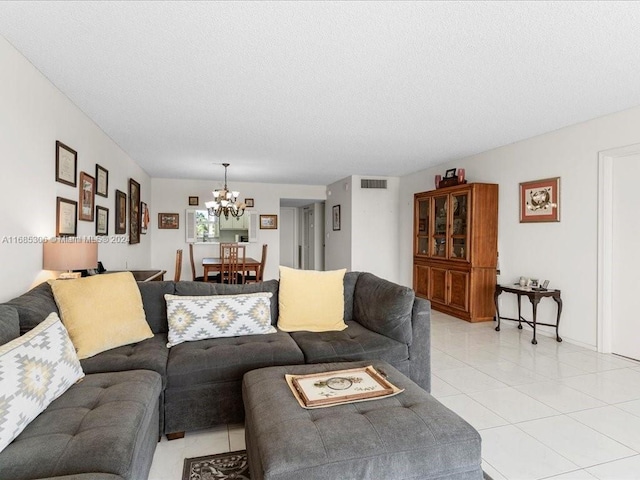 living room featuring light tile patterned flooring, a textured ceiling, and a notable chandelier