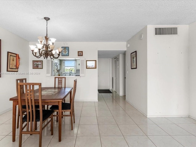 dining area with light tile patterned floors, a chandelier, and a textured ceiling