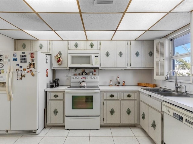 kitchen with light tile patterned floors, white appliances, and sink