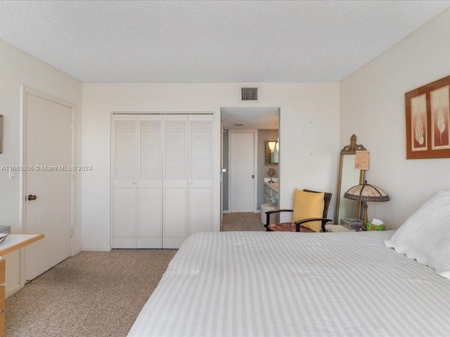 carpeted bedroom featuring a textured ceiling and a closet