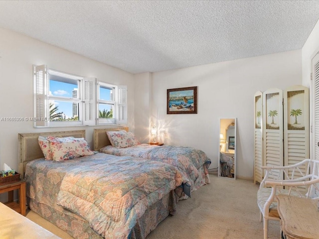 bedroom with light carpet and a textured ceiling