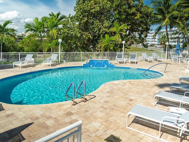 view of pool featuring pool water feature and a patio