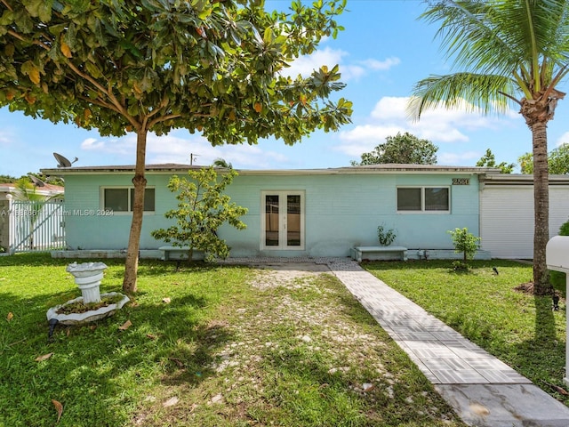 rear view of property featuring french doors and a lawn