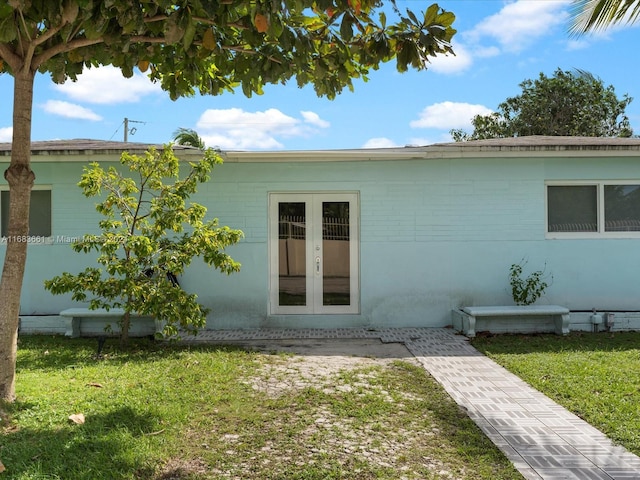 back of house with french doors and a yard