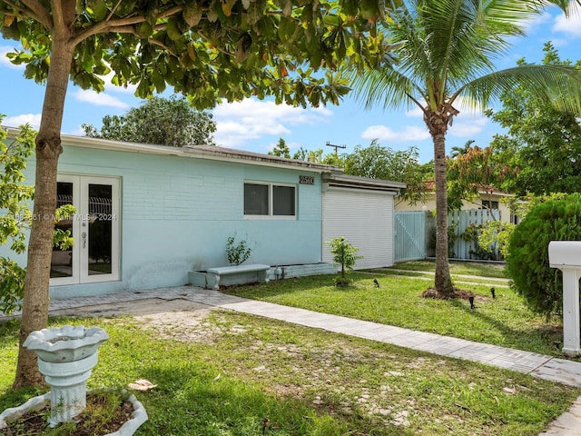 view of side of home with french doors and a yard