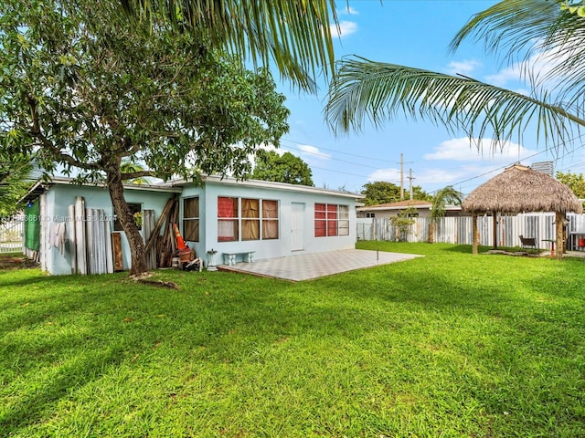 rear view of property featuring a yard and a patio area