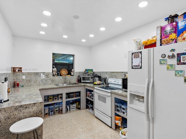 kitchen with white appliances, backsplash, and sink