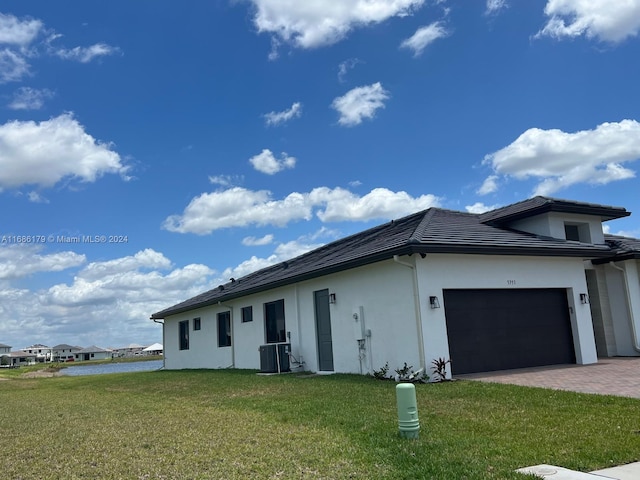 view of home's exterior with a yard, a garage, and cooling unit