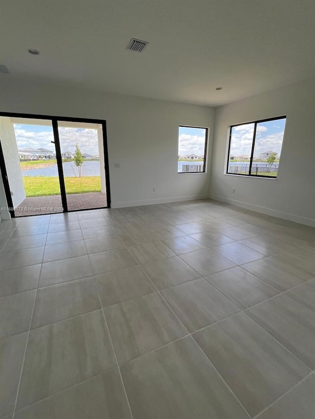 tiled spare room featuring plenty of natural light