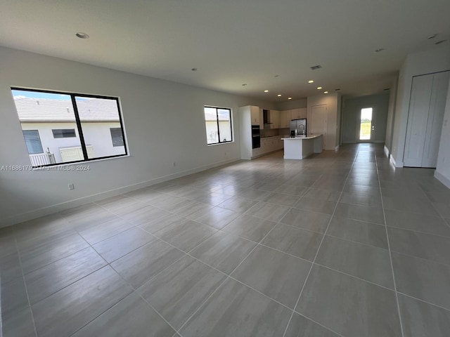 unfurnished living room with light tile patterned floors