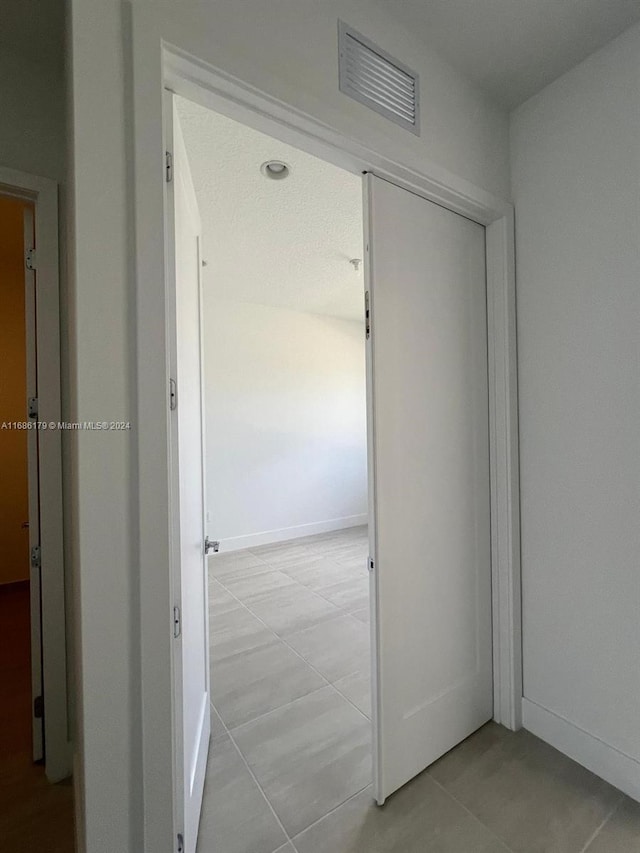 hallway featuring light tile patterned floors