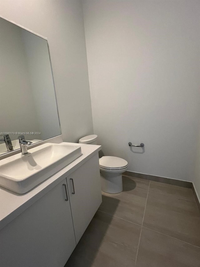 bathroom featuring toilet, vanity, and tile patterned floors