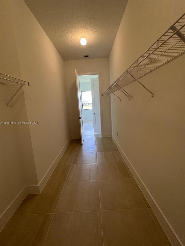 corridor featuring tile patterned floors and a textured ceiling