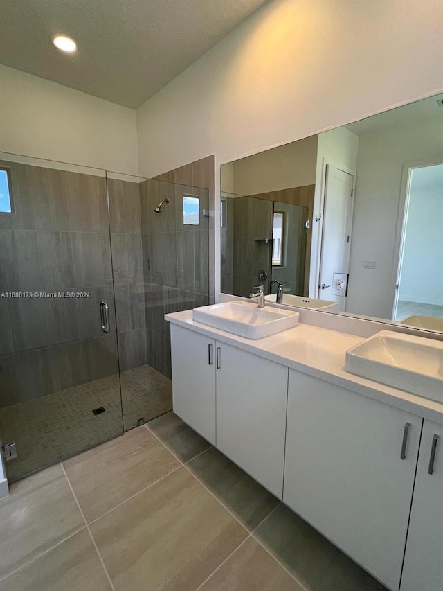 bathroom featuring tile patterned floors, vanity, and a shower with shower door