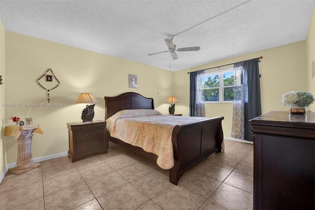 bedroom featuring a textured ceiling, light tile patterned flooring, and ceiling fan