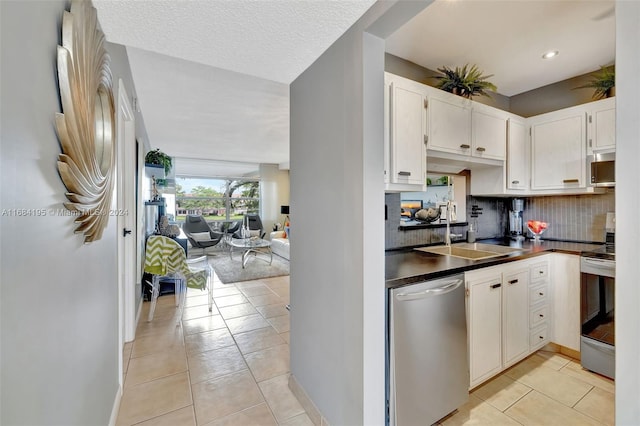 kitchen with white cabinetry, stainless steel appliances, sink, and light tile patterned floors