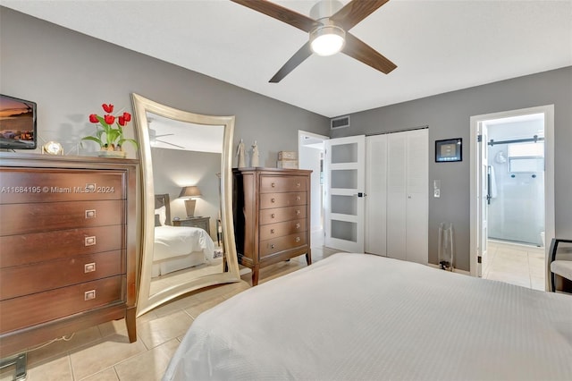 tiled bedroom featuring connected bathroom, a closet, and ceiling fan