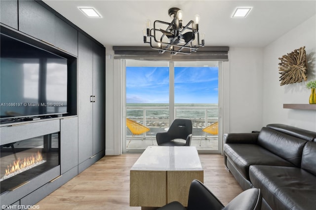 interior space with light hardwood / wood-style flooring, a chandelier, and a water view