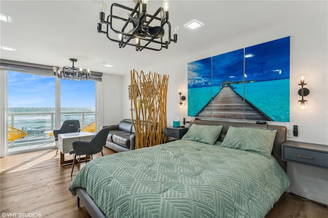 bedroom featuring hardwood / wood-style flooring and a water view