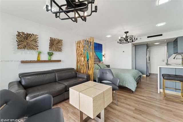 living room featuring light hardwood / wood-style floors, a chandelier, and sink