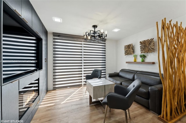 living room with an inviting chandelier and light hardwood / wood-style floors