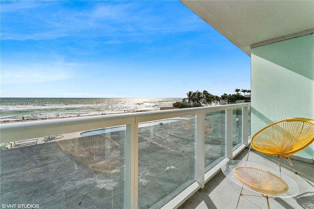 balcony with a water view and a beach view