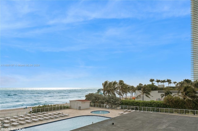 view of pool featuring a water view and a patio