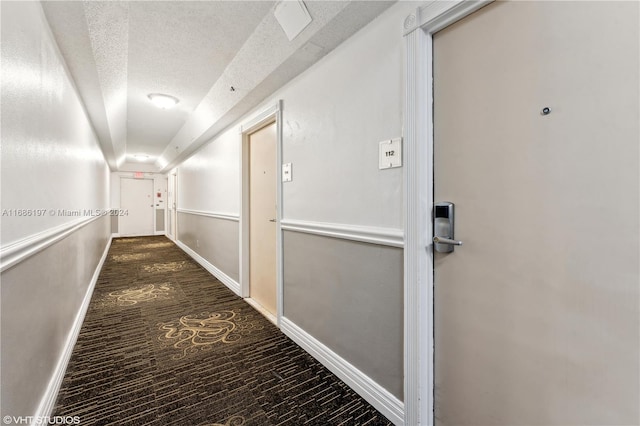 hallway featuring dark wood-type flooring and a textured ceiling