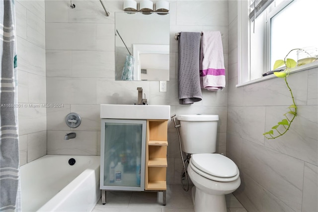 full bathroom with tile walls, toilet, shower / bath combo with shower curtain, vanity, and tile patterned floors