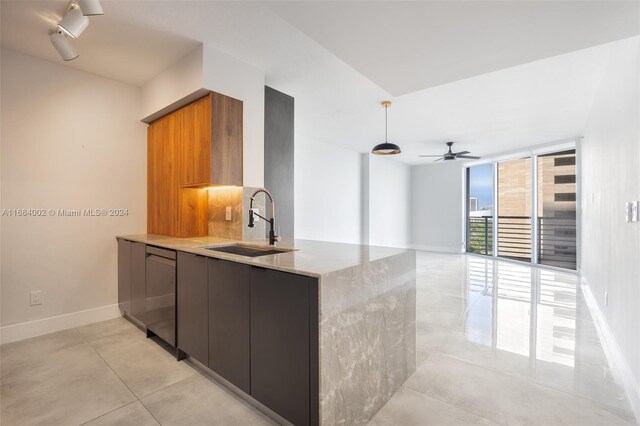 kitchen featuring sink, light stone counters, dishwasher, and ceiling fan