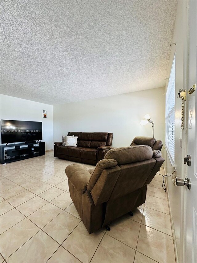 living room with a textured ceiling and light tile patterned floors