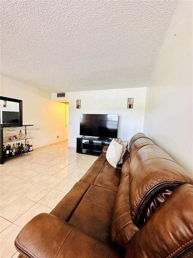 living room featuring a textured ceiling and light tile patterned flooring