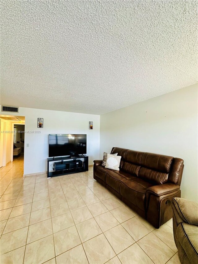 living room featuring light tile patterned flooring and a textured ceiling