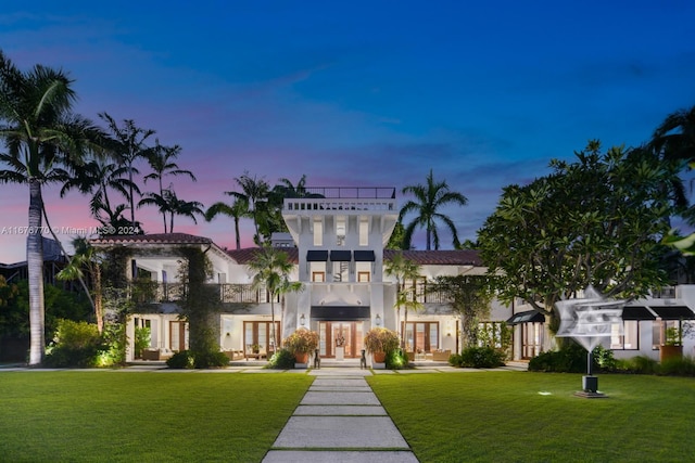 view of front of property featuring french doors and a yard