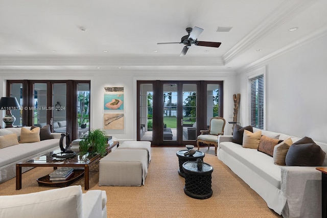 living room with french doors, crown molding, a tray ceiling, and ceiling fan