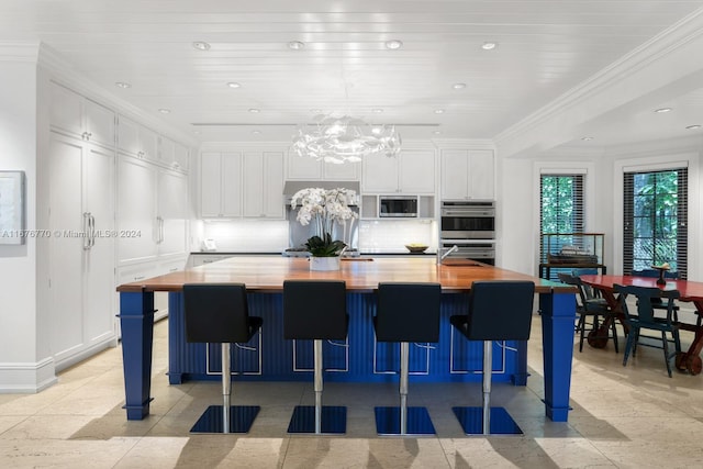 kitchen with white cabinetry and a large island with sink