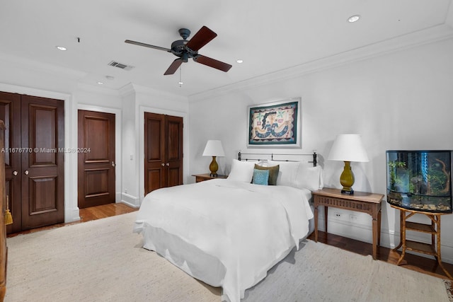 bedroom with ceiling fan, ornamental molding, and light hardwood / wood-style floors