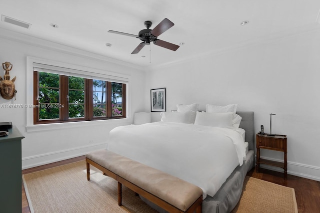 bedroom with ceiling fan, ornamental molding, and dark hardwood / wood-style floors