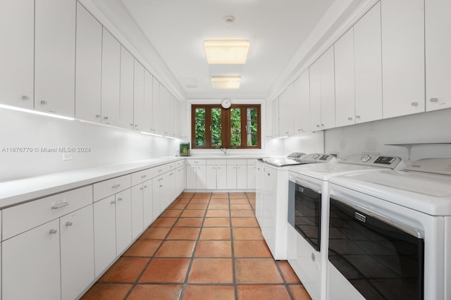 laundry room with cabinets, washer and dryer, and light tile patterned flooring