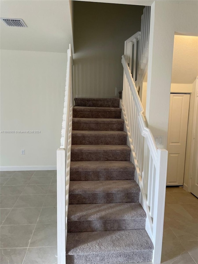 staircase with tile patterned floors