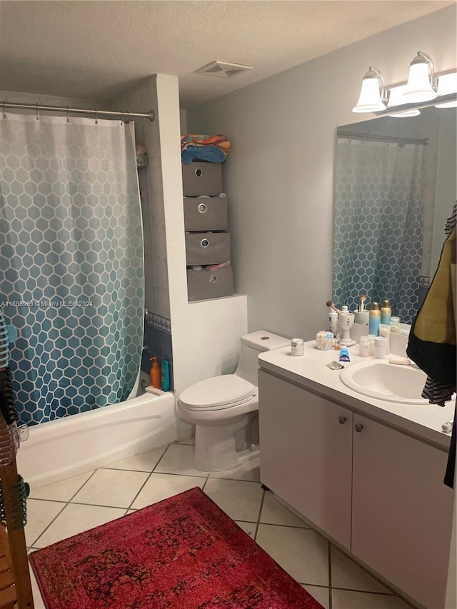 full bathroom featuring tile patterned floors, toilet, shower / tub combo, vanity, and a textured ceiling