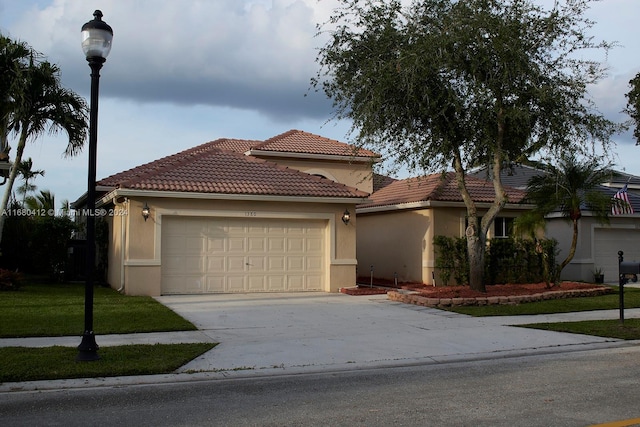 1380 Meadows Blvd, Weston, FL 33327 - mediterranean / spanish-style house with driveway, a garage, stucco siding, and a tiled roof
