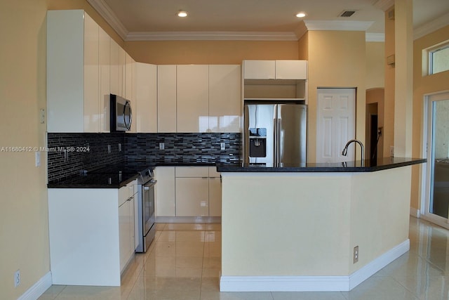 kitchen featuring backsplash, light tile patterned floors, ornamental molding, appliances with stainless steel finishes, and white cabinetry