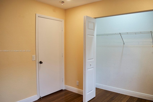 unfurnished bedroom with dark wood-type flooring and a closet