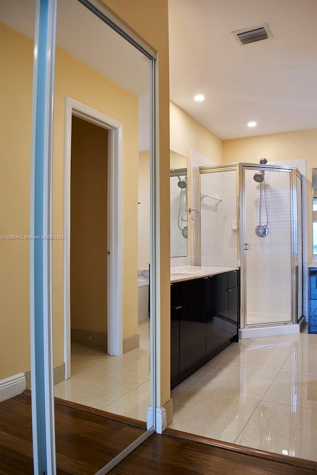 bathroom with wood-type flooring, vanity, and walk in shower