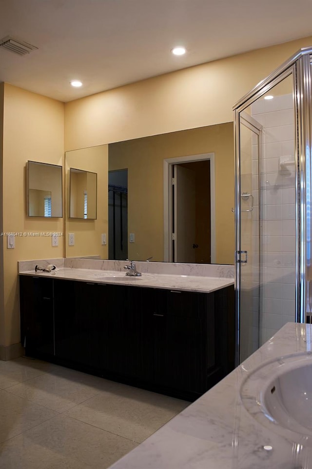 bathroom with vanity, tile patterned floors, and a shower with door